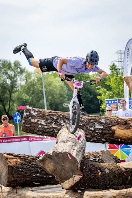 NOEMIE GFELLER en équilibre sur la roue avant au-dessus d’obstacles en bois